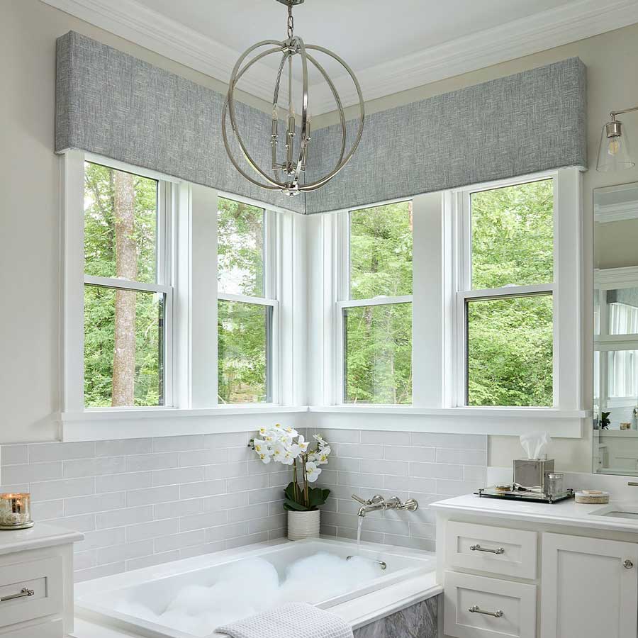 gray valences ontop of windows in bathroom with a tub