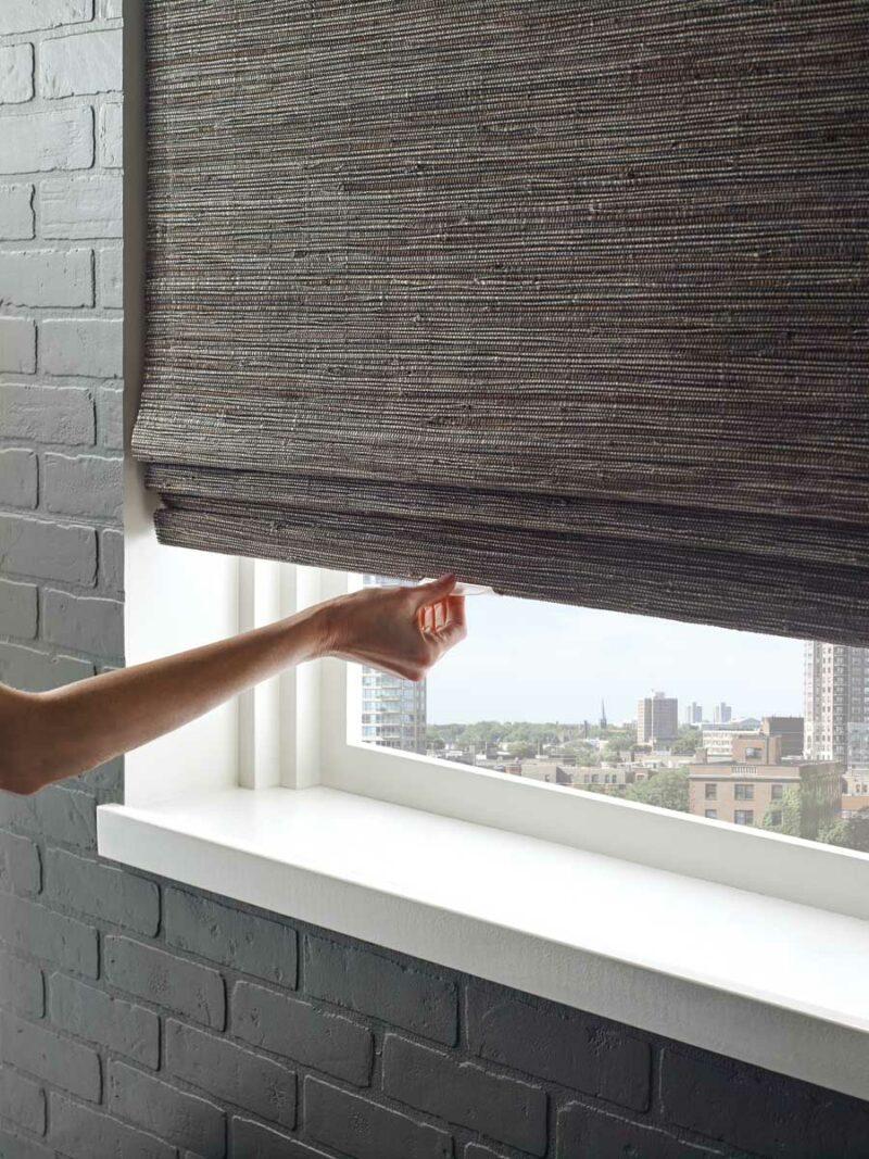 gray woven wood window shades on window of a bedroom